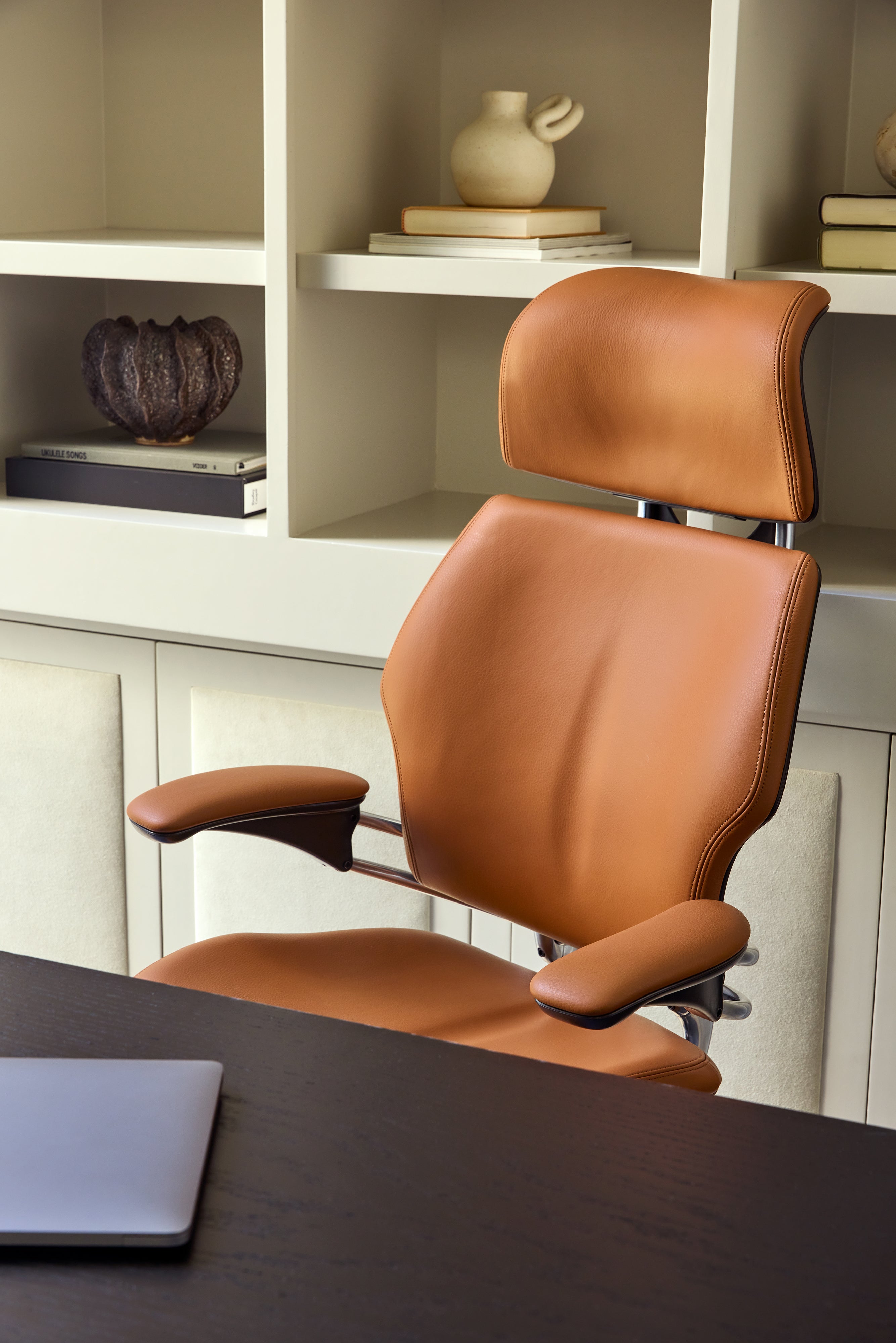 Side view of Brown Saddle Leather Humanscale Freedom Ocean headrest chair in modern office