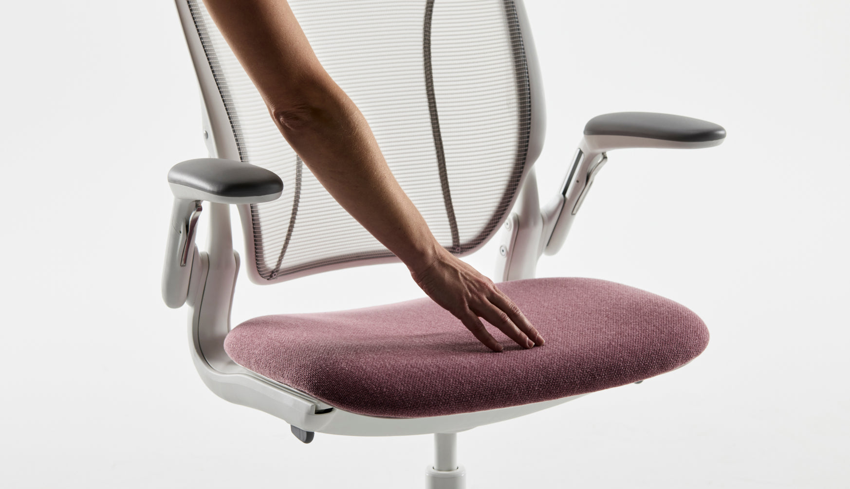 Hand touching Kvadrat Autumn seat on Humanscale Diffrient World Pinstripe White mesh chair