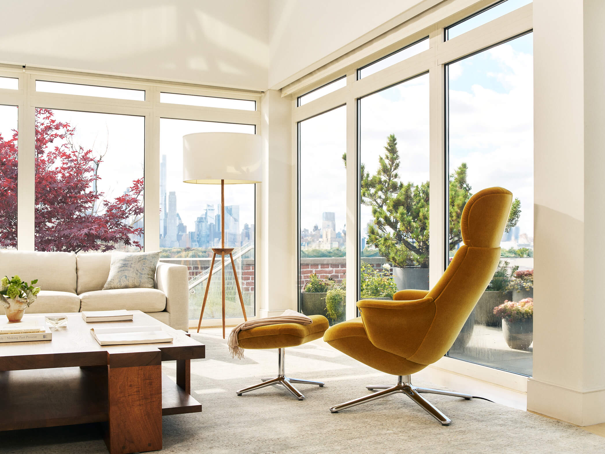 Mustard yellow Humanscale Diffrient Lounge chair with matching ottoman in sunny living room city view