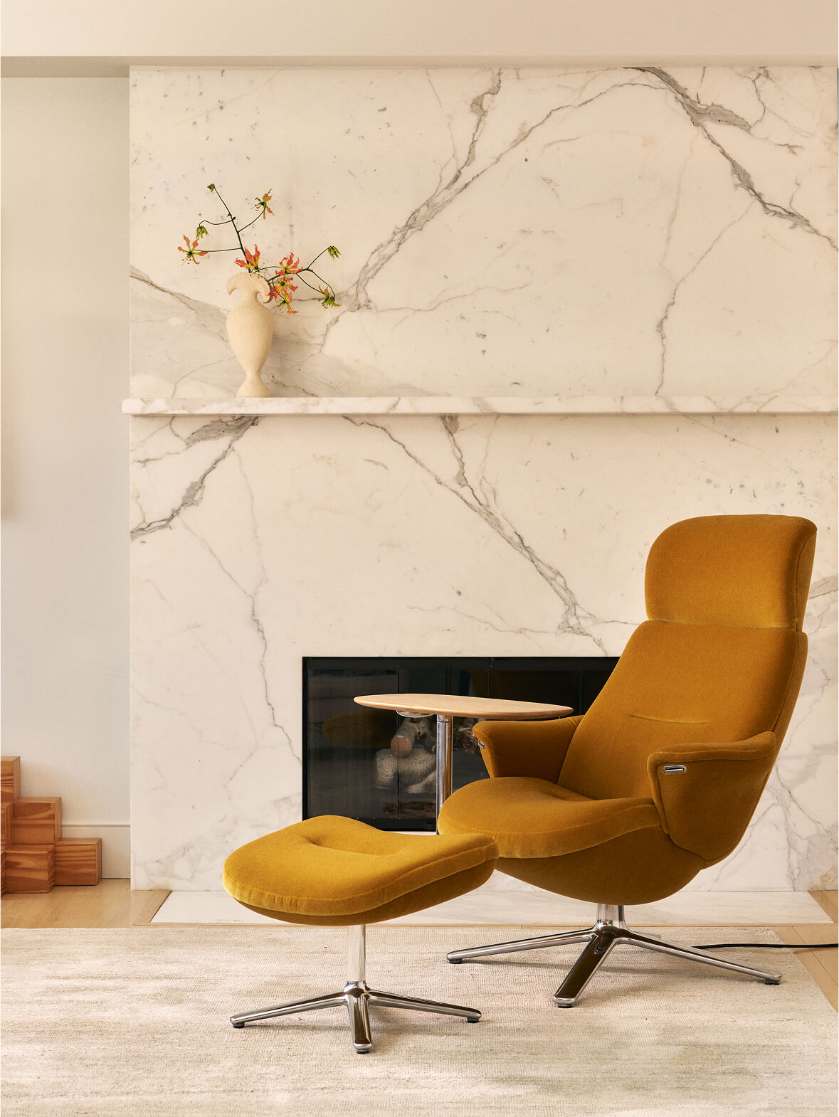 Mustard Humanscale Diffrient Lounge chair with ottoman and lside table in front of fireplace