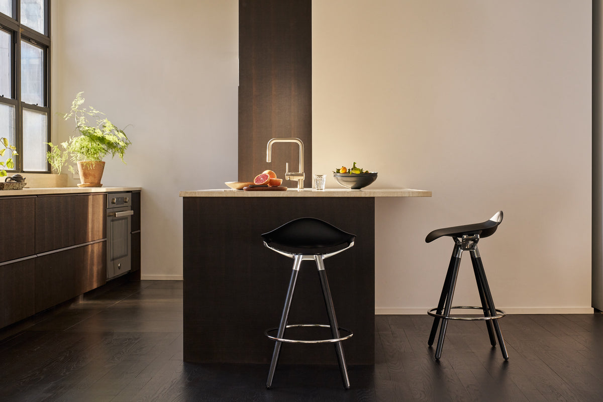 A side and front view differentiation of a Humanscale Sedeo stool with solid maple wood legs, black frame, and black seat, featuring a side view of one stool and a front view of the other