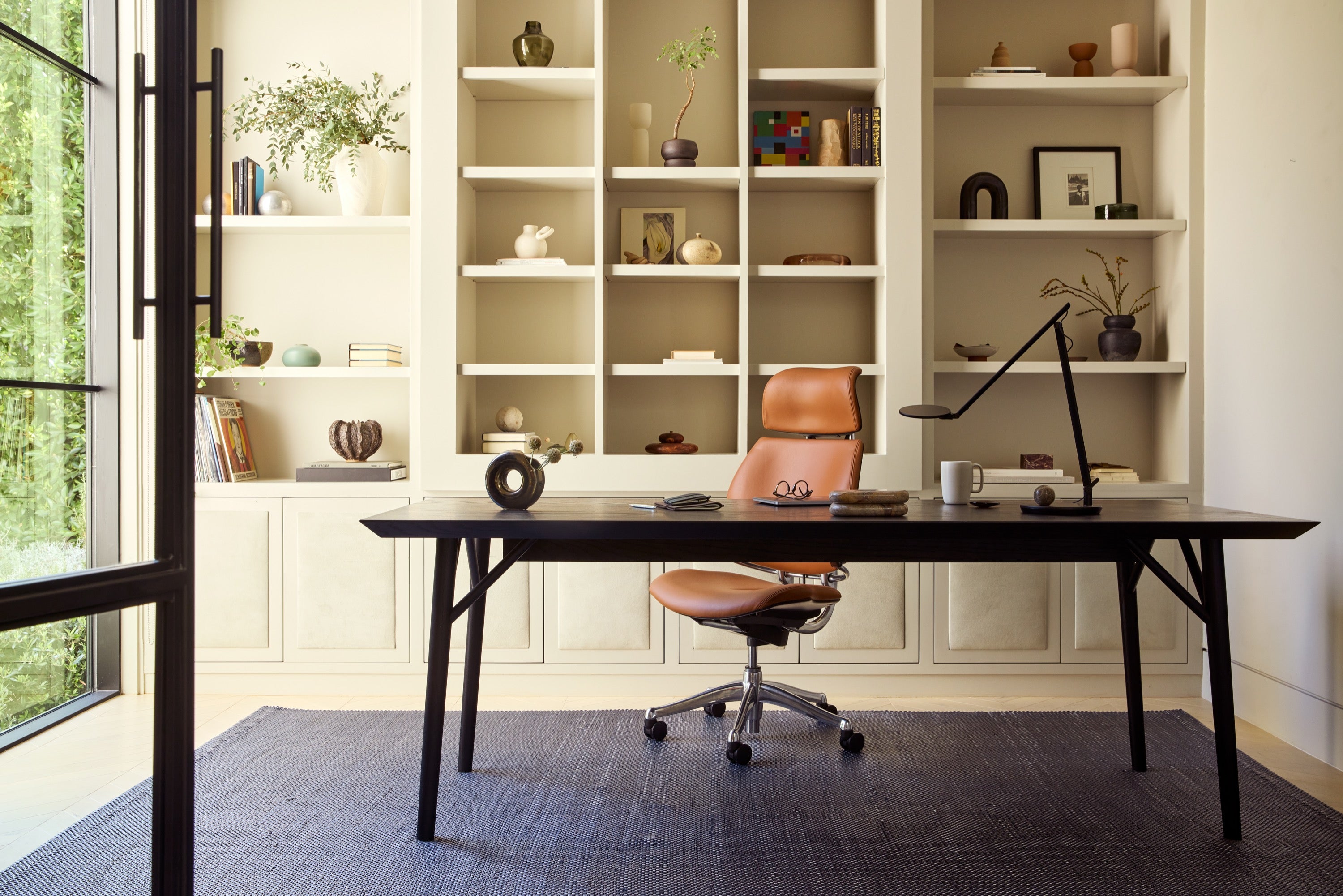 Freedom headrest in a saddle leather with a desk, chair, and bookshelves.