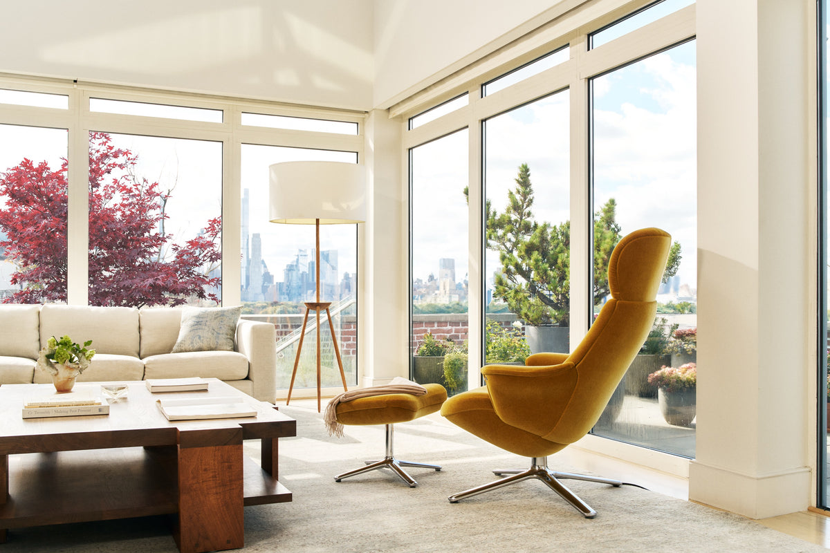Mustard yellow Humanscale Diffrient Lounge chair with matching ottoman in sunny living room city view