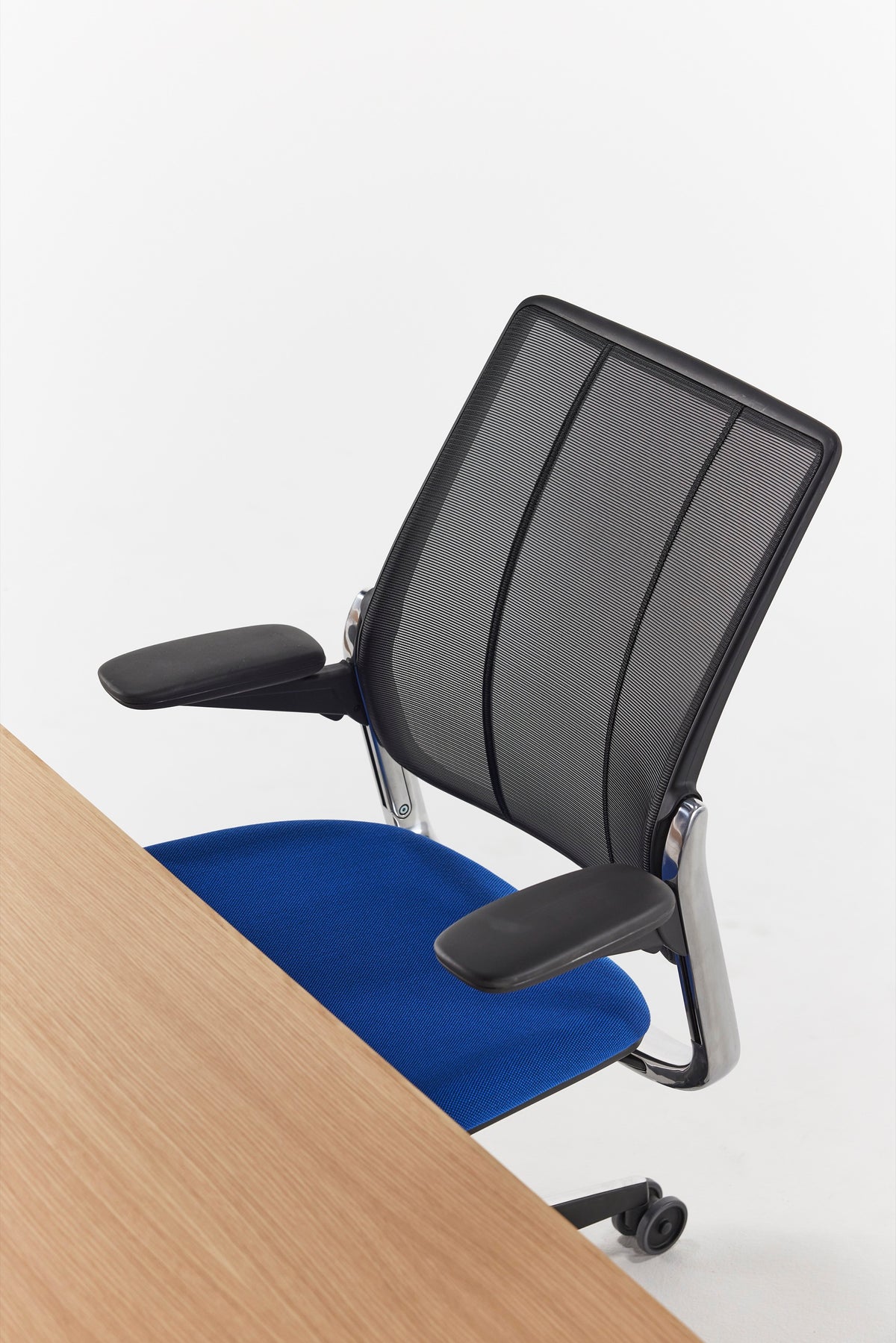 Humanscale Diffrient Smart Ocean chair featuring pinstripe black mesh and an azure textile seat with a black frame next to a light wood desk