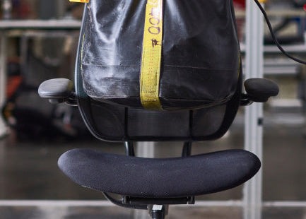 Humanscale Liberty Ocean task chair with pinstripe black mesh and black frame in an industrial gym setting with a leather punching bag