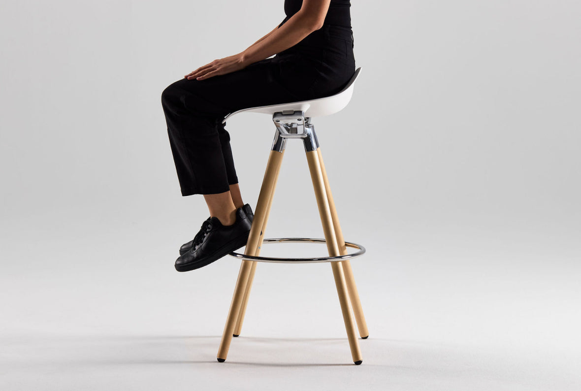 Woman resting feet on Humanscale Sedeo stool aluminum foot ring base.