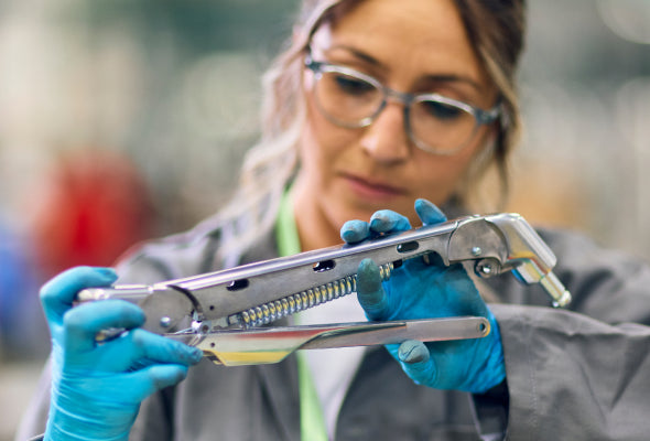 Person inspecting Humanscale Re-Freshed circularity program chair mechanical component.