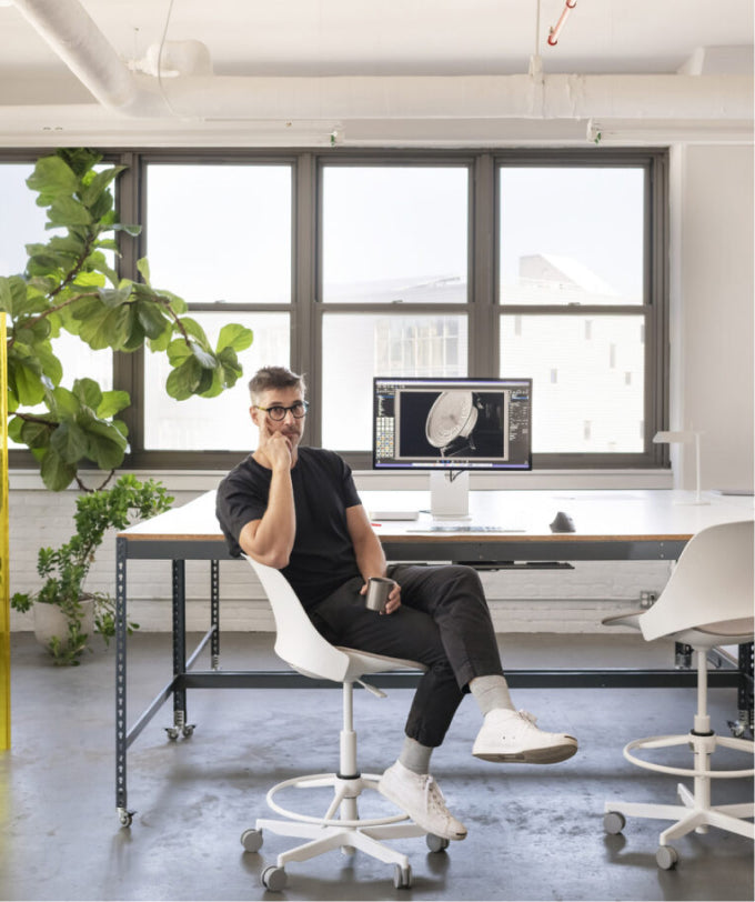 Person seated on a Humanscale Trea high task stool with a foot ring