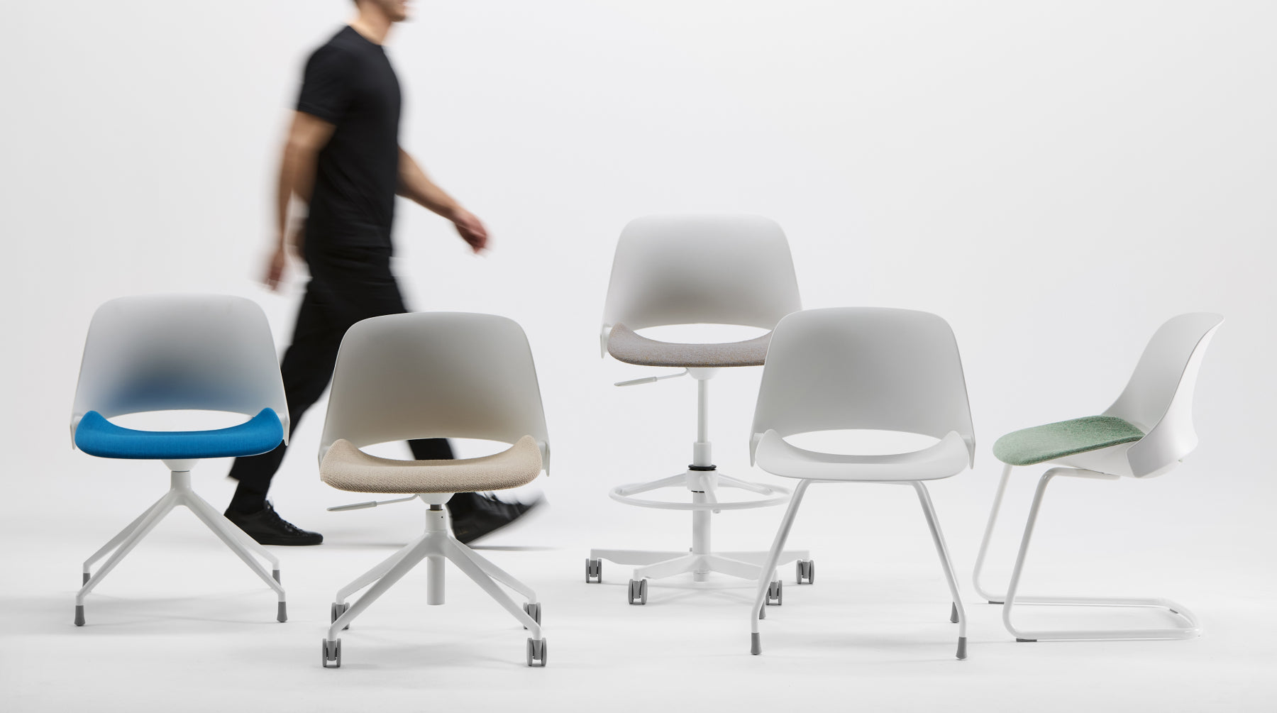 Five Humanscale Trea chairs in various colors with different base configurations
